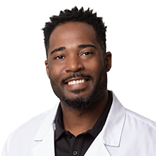 Dr. Ray Tucker, DDS, pediatric dentist in Las Vegas, smiling in a white coat